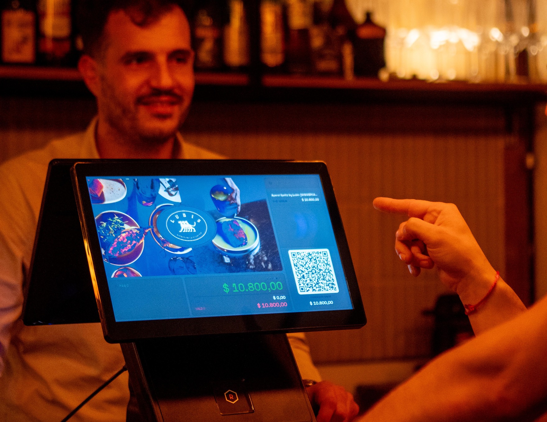 El Los Angeles operando en el mostrador de un bar, con un cliente usando la pantalla